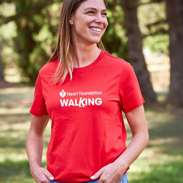 Woman wearing a red Heart Foundation Walking t-shirt in a park setting