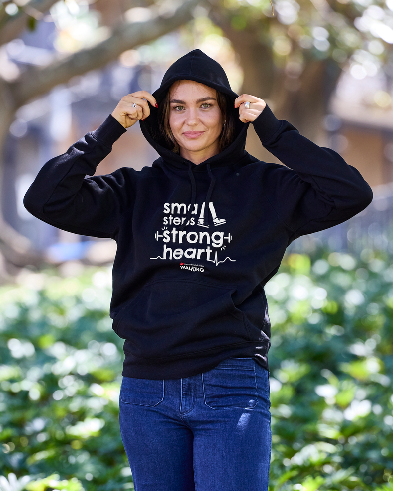 Woman wearing a black hoodie with text outdoors