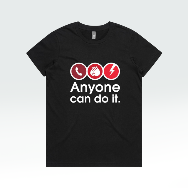 A black short-sleeve crewneck t-shirt with a graphic on the chest showing three red circular icons (a telephone, a hand, and a lightning bolt) above the white text 'Anyone can do it.'.