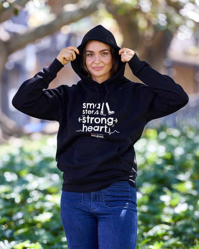 Woman wearing a black hoodie with text outdoors