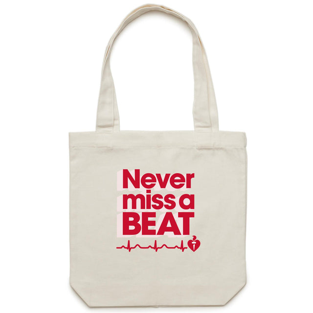 Cream tote bag with red and pale pink print with logo shown on white background.