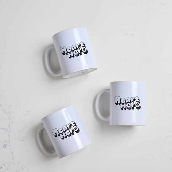 Heart Foundation white ceramic mug with Heart Hero print in  black vintage style font.