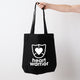 Heart Foundation black canvas tote bag shown held in hand with Heart warrior design in white print. on the front