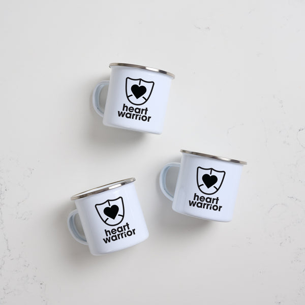 Heart Foundation white enamel mug with silver rim and heart warrior print in black