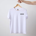 Women's short sleeve white Heart Foundation t-shirt displayed on hanger with XOXO print to left chest.