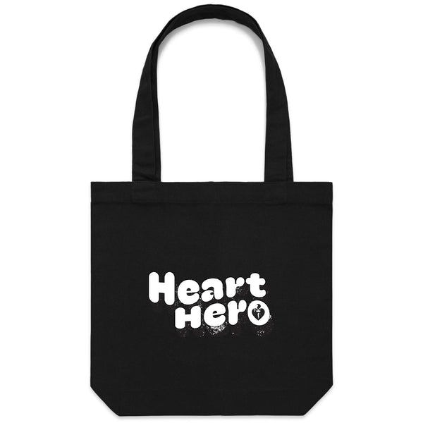Heart Foundation black canvas tote bag shown with vintage look Heart hero text in white print on the front